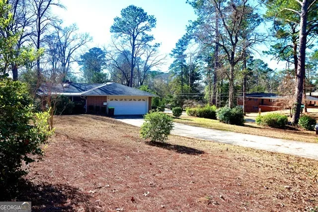 a front view of a house with a yard and trees