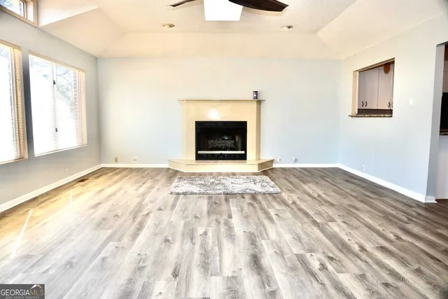 a view of empty room with wooden floor and fireplace