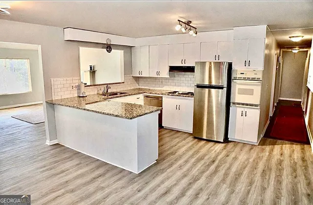 a kitchen with white cabinets and stainless steel appliances