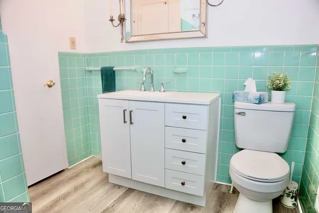 a bathroom with a toilet sink and mirror