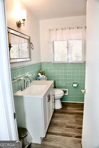 a bathroom with a sink a toilet and mirror