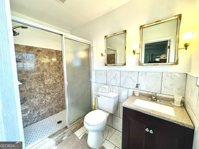 a bathroom with a granite countertop sink toilet and shower