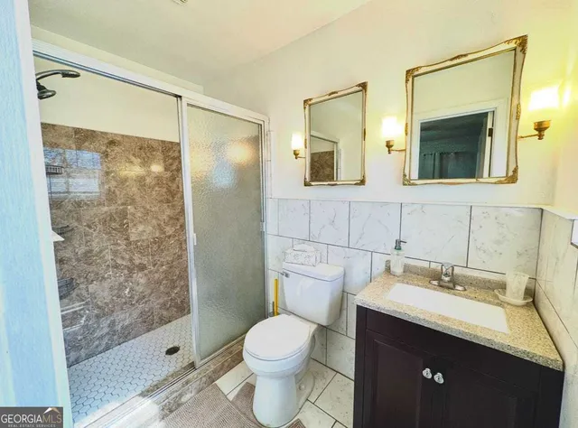a bathroom with a granite countertop sink toilet and shower