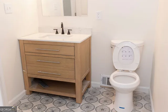 a bathroom with a toilet a sink and a mirror