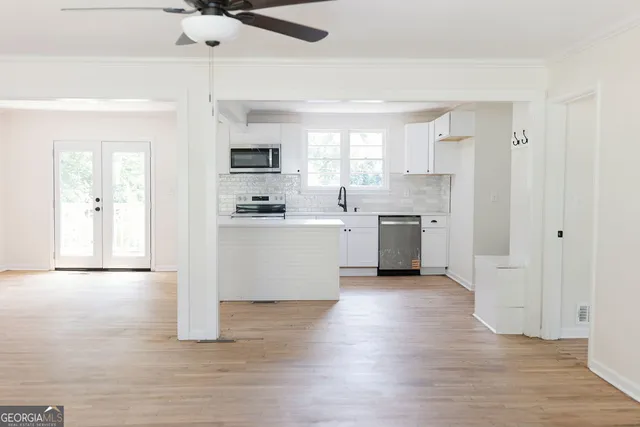 a view of a kitchen with a sink and dishwasher a refrigerator with wooden floor