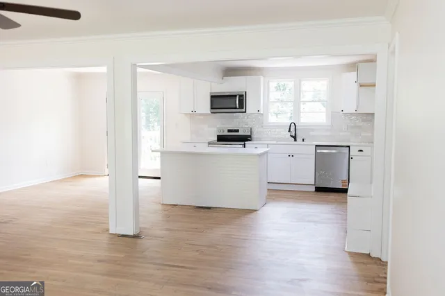 a kitchen with stainless steel appliances a stove top oven a sink a refrigerator a window