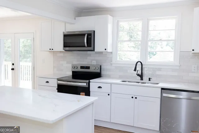 a kitchen with white cabinets and a sink