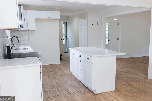 a kitchen with kitchen island a sink a stove and refrigerator