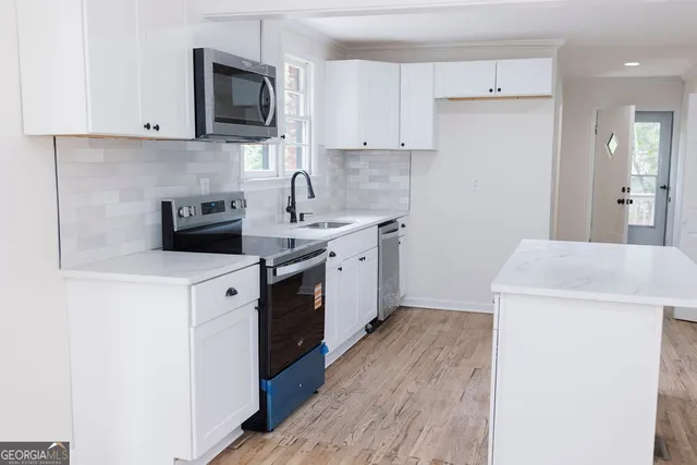 a kitchen with a sink a stove and cabinets