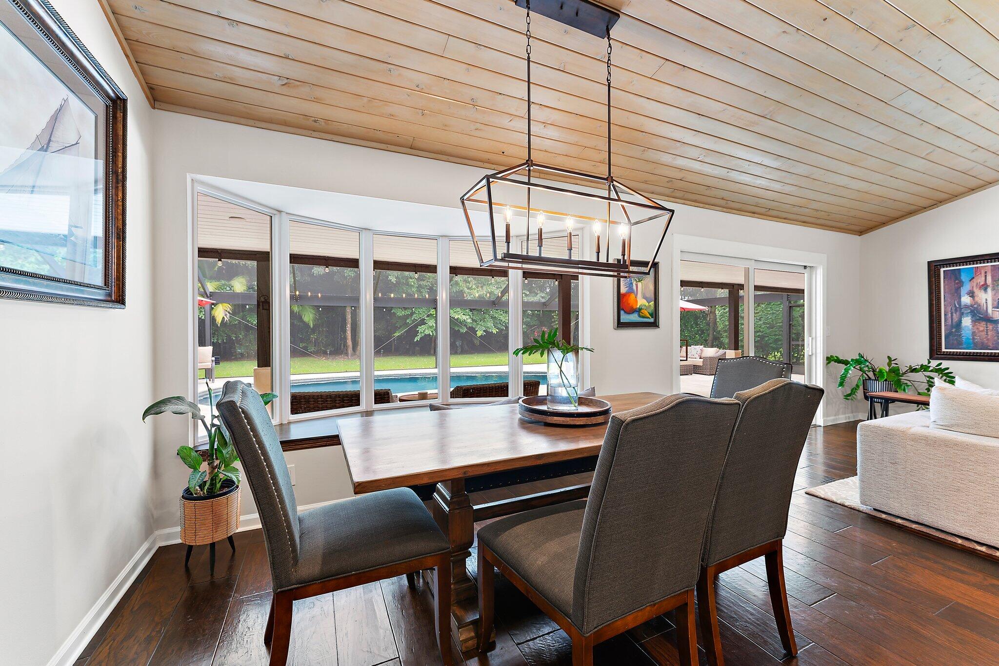 19546 Red Gum Trail Jupiter, FL 33458 - Photo 14 of 42 a dining room with wooden floor a chandelier a glass table and chairs
