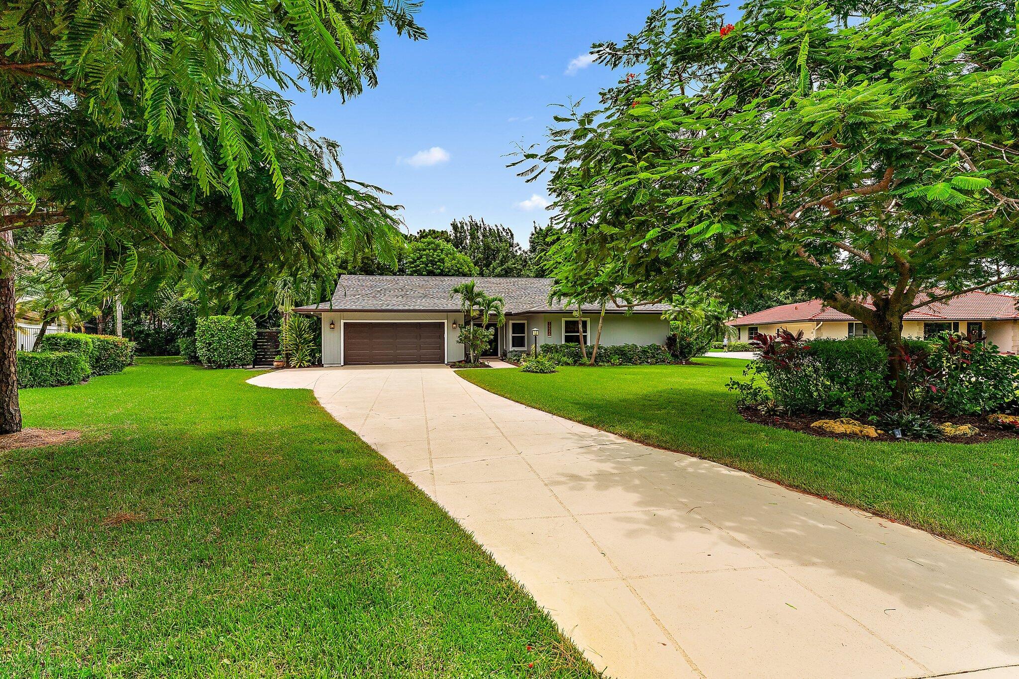19546 Red Gum Trail Jupiter, FL 33458 - Photo 2 of 42 a house with garden in front of it