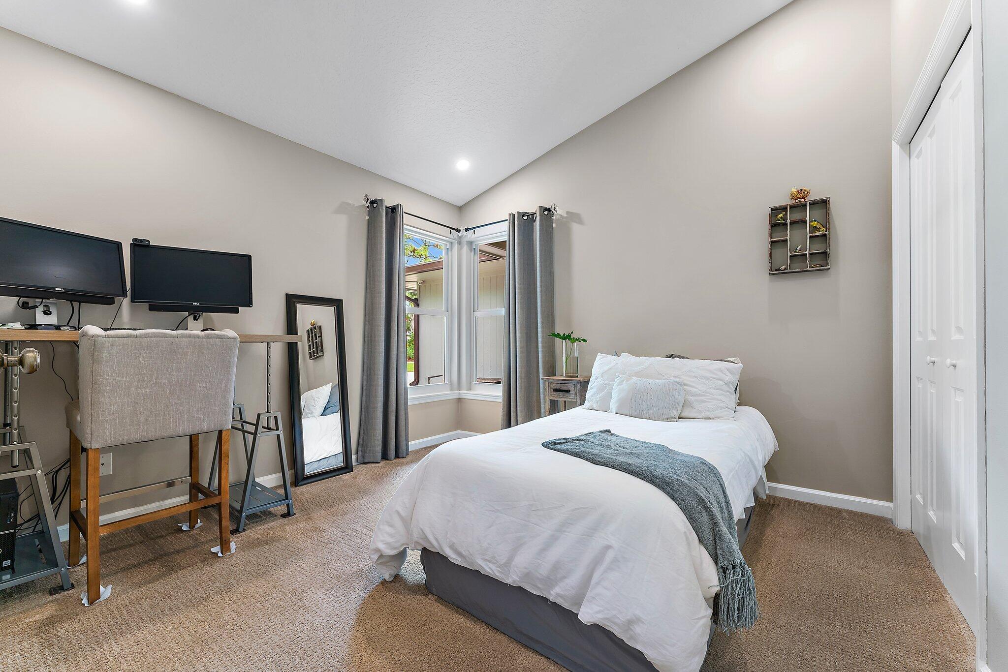 19546 Red Gum Trail Jupiter, FL 33458 - Photo 25 of 42 a bedroom with a bed a chair and flat screen tv