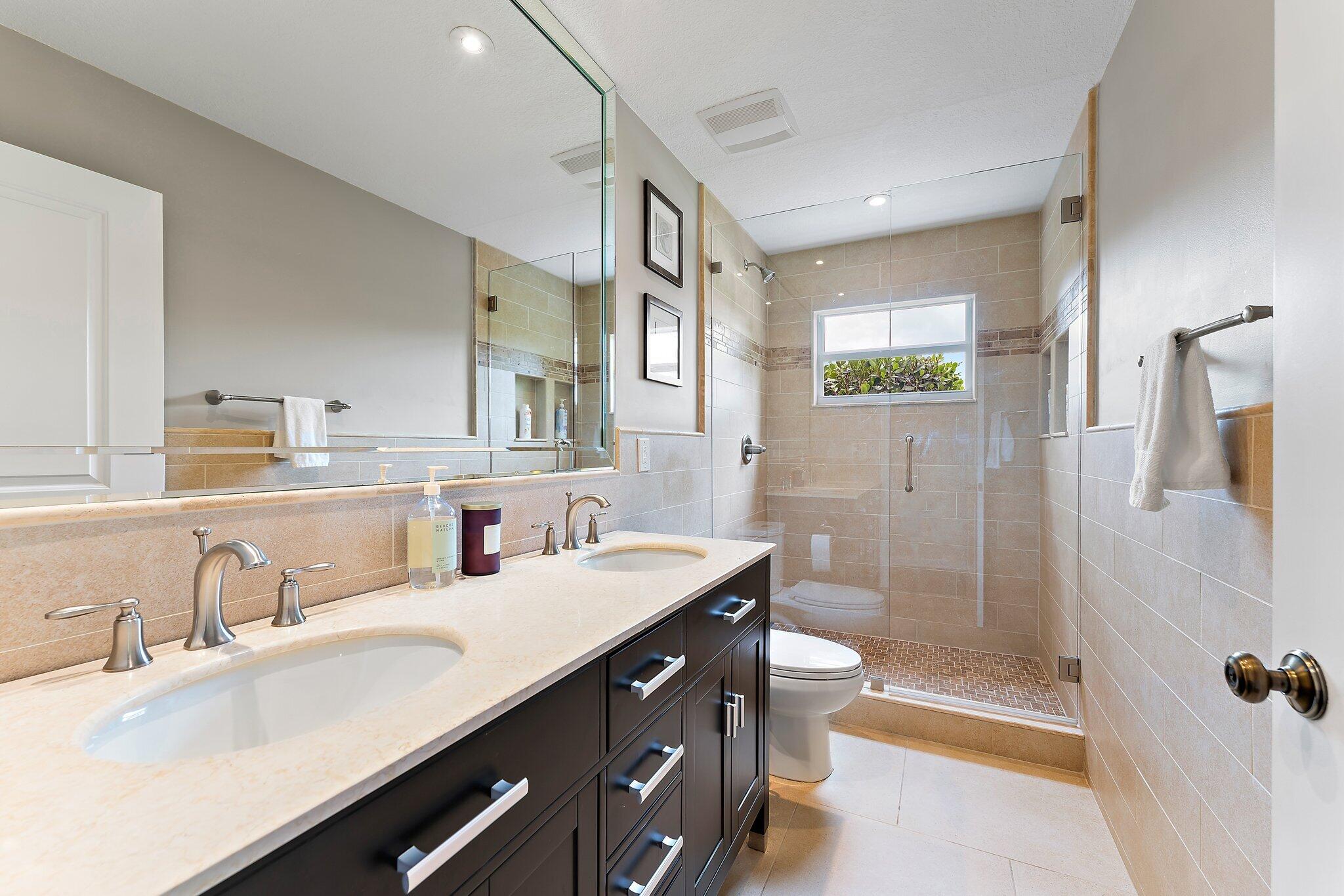 19546 Red Gum Trail Jupiter, FL 33458 - Photo 27 of 42 a bathroom with a double vanity sink toilet and shower