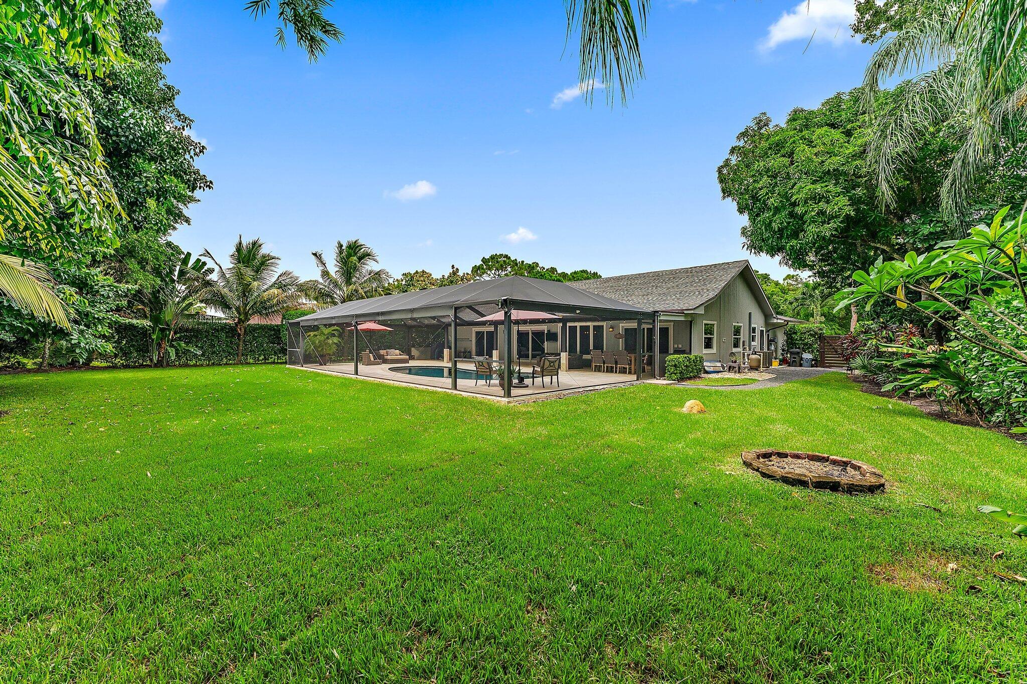 19546 Red Gum Trail Jupiter, FL 33458 - Photo 38 of 42 a front view of a house with a garden