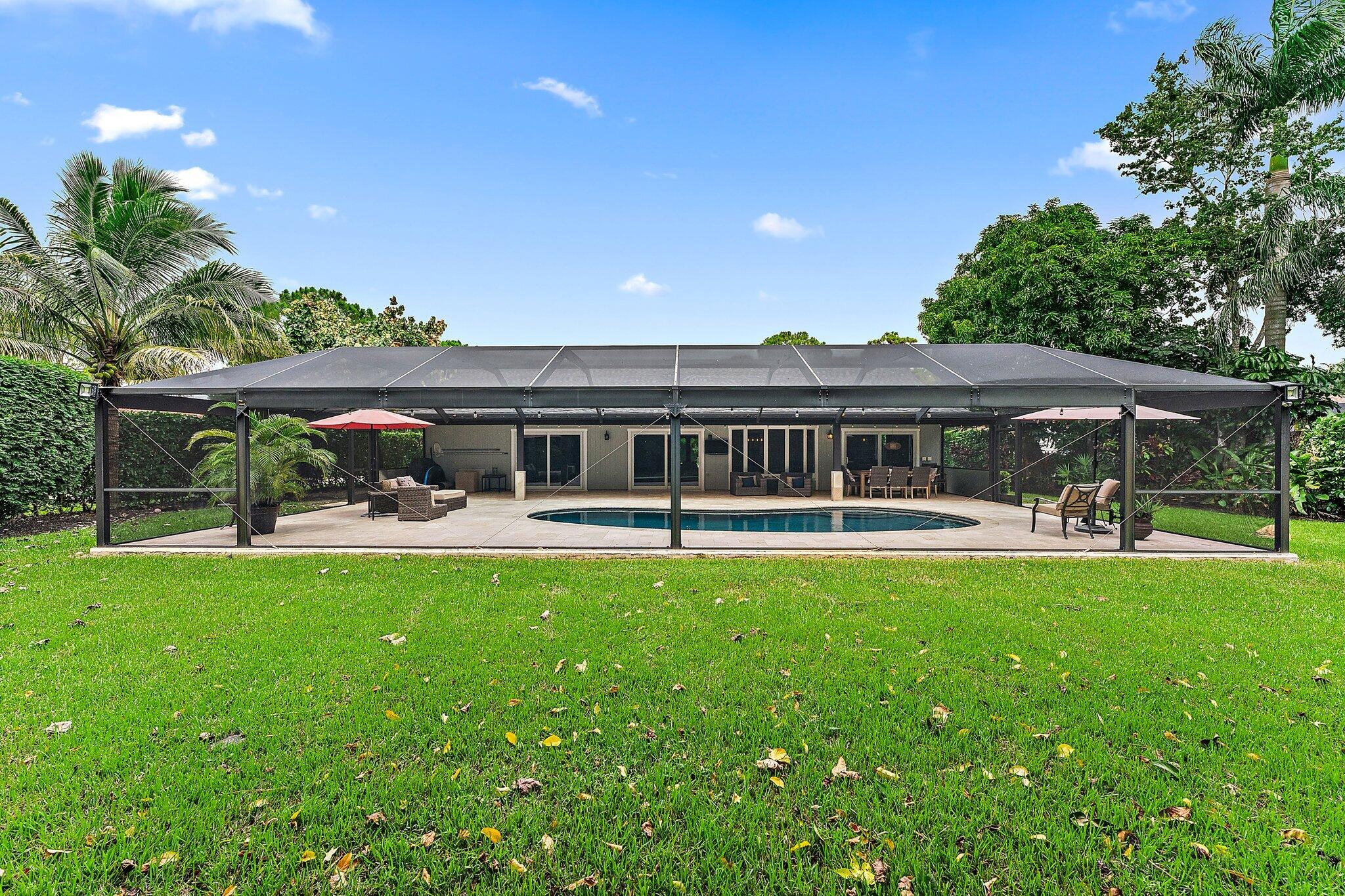 19546 Red Gum Trail Jupiter, FL 33458 - Photo 39 of 42 a front view of a house with swimming pool having outdoor seating