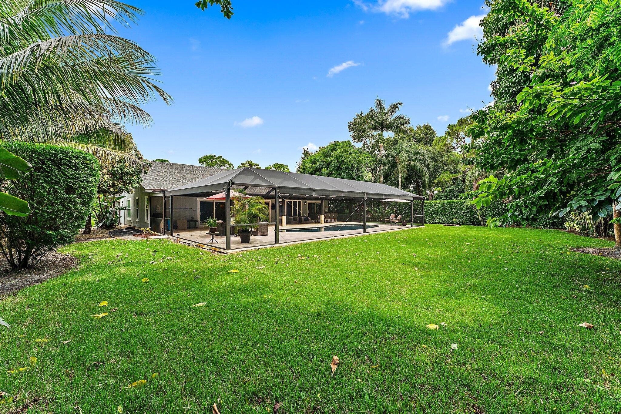 19546 Red Gum Trail Jupiter, FL 33458 - Photo 40 of 42 a front view of house with yard and outdoor seating
