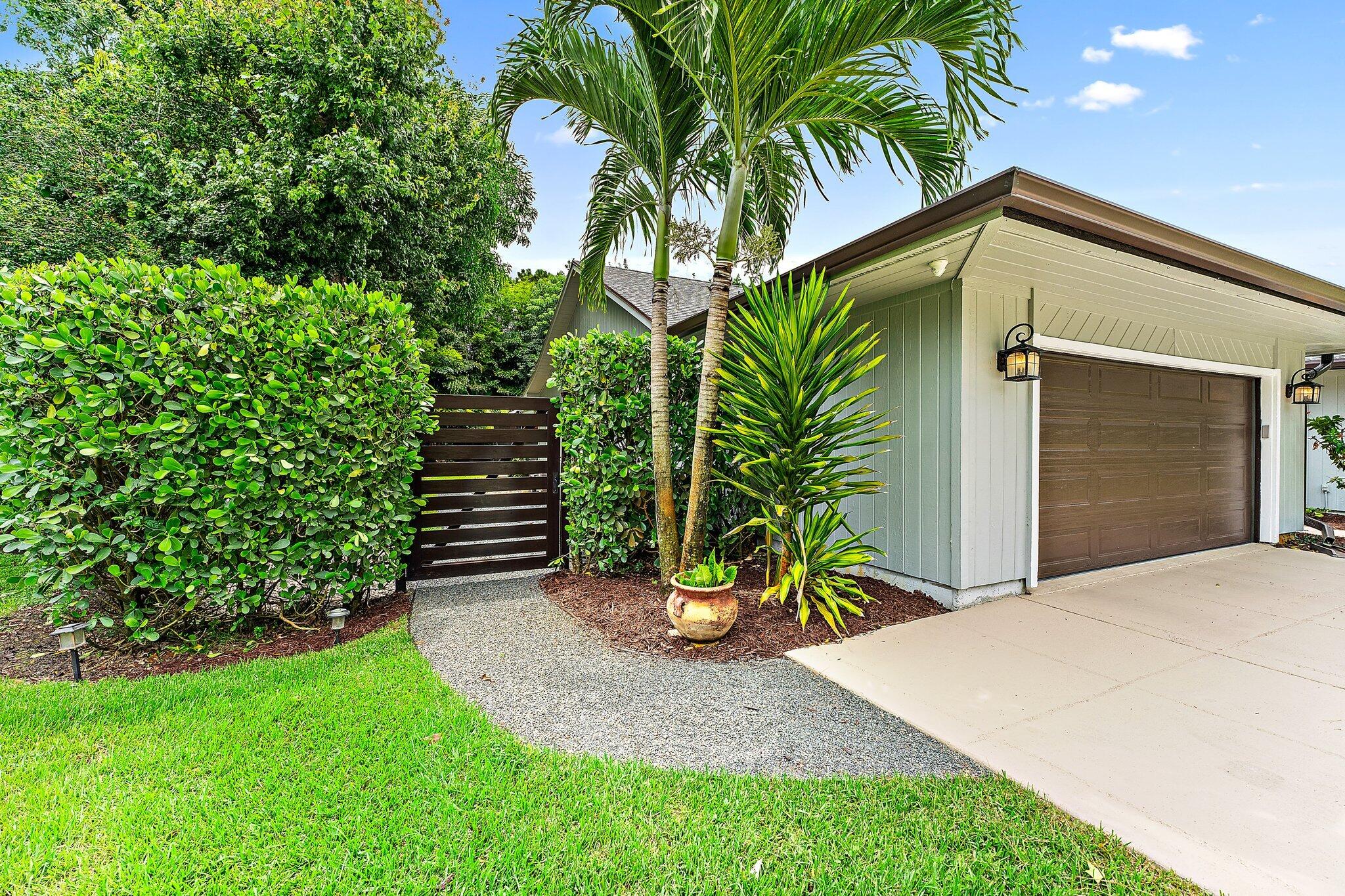 19546 Red Gum Trail Jupiter, FL 33458 - Photo 7 of 42 a view of a backyard with plants and a palm tree