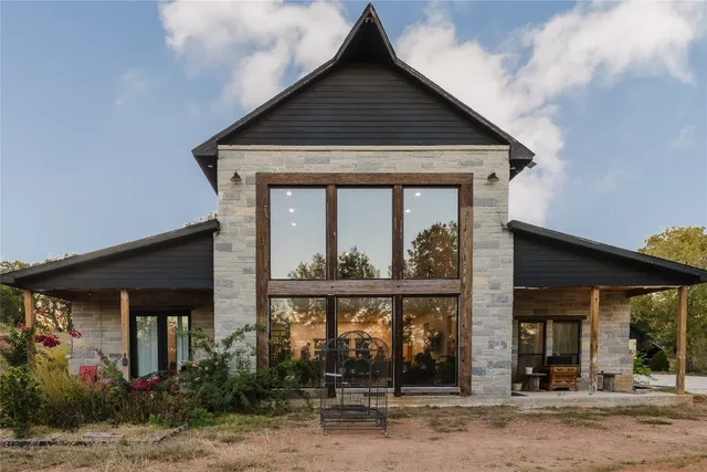 a front view of a house with glass windows and a yard