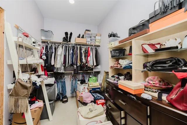 a view of walk in closet with clothes and shoes