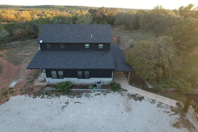 a aerial view of a house with a yard and large tree
