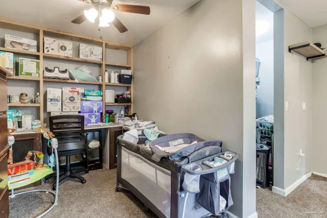 a view of a workspace with furniture and a window