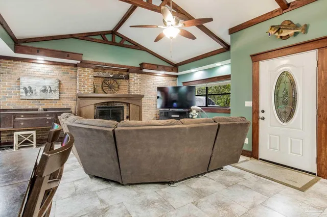 a living room with furniture a flat screen tv and a ceiling fan