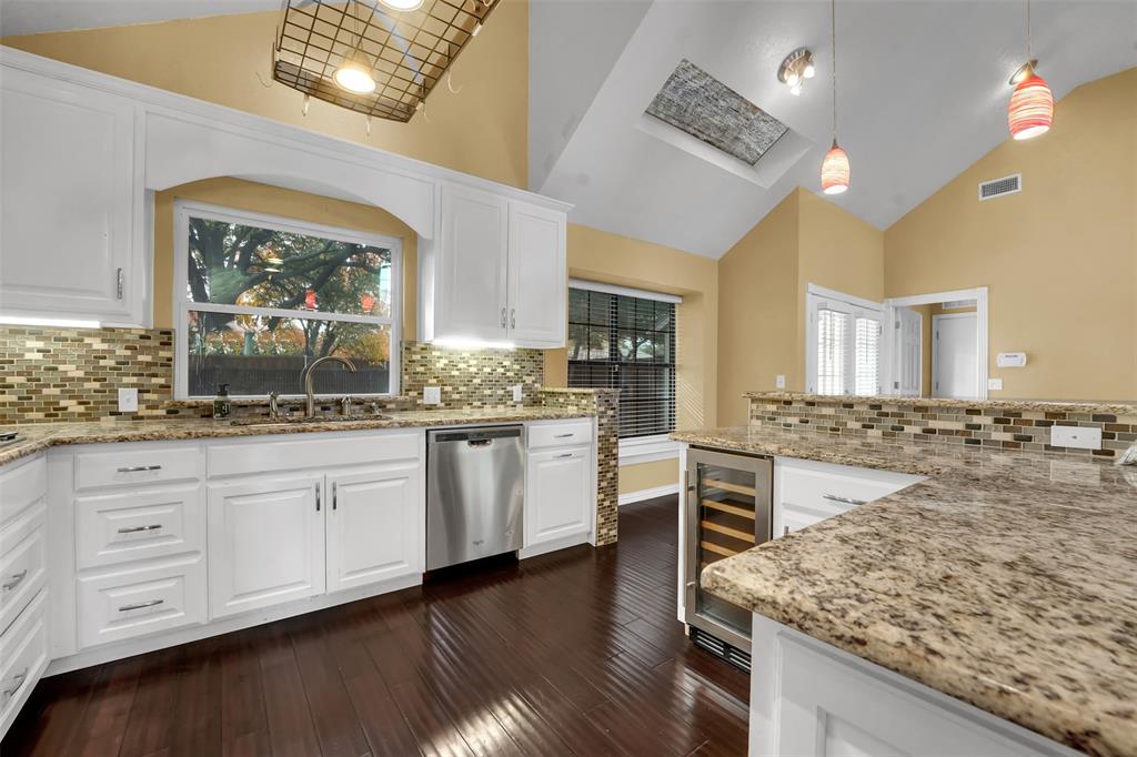 3410 Ridge Oak Drive Garland, TX 75044 - Photo 13 of 29 a open kitchen with stainless steel appliances granite countertop a stove and white cabinets with wooden floor
