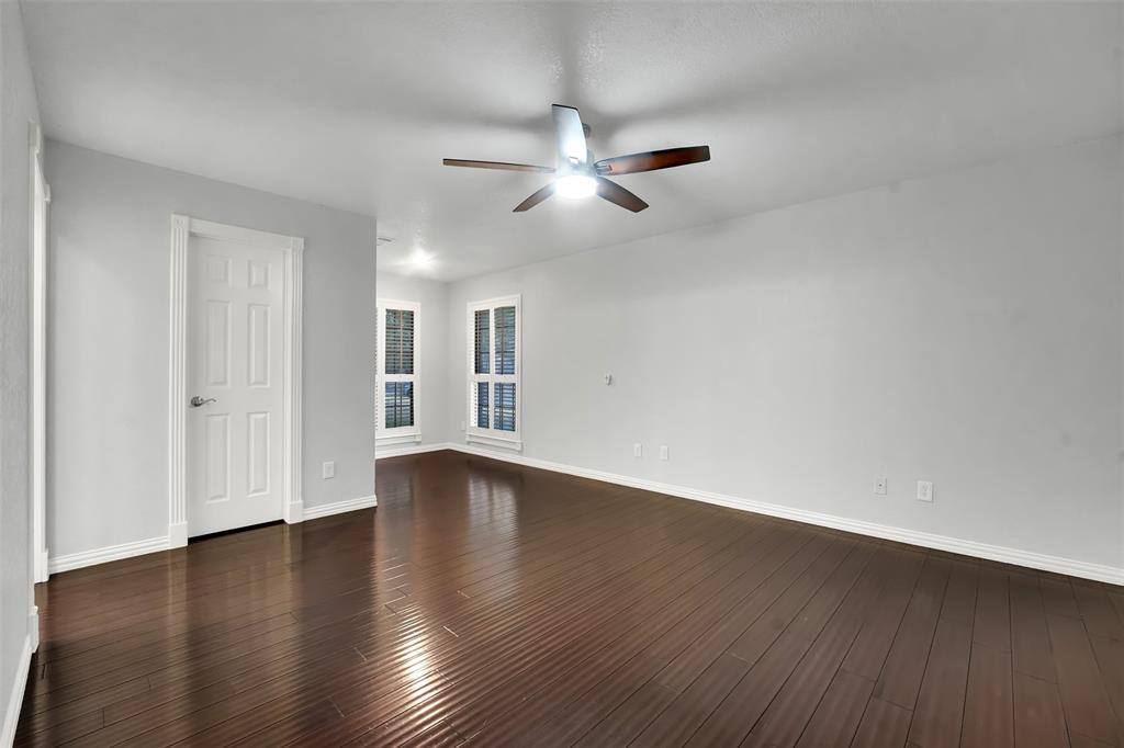 3410 Ridge Oak Drive Garland, TX 75044 - Photo 17 of 29 a view of an empty room with wooden floor and a ceiling fan