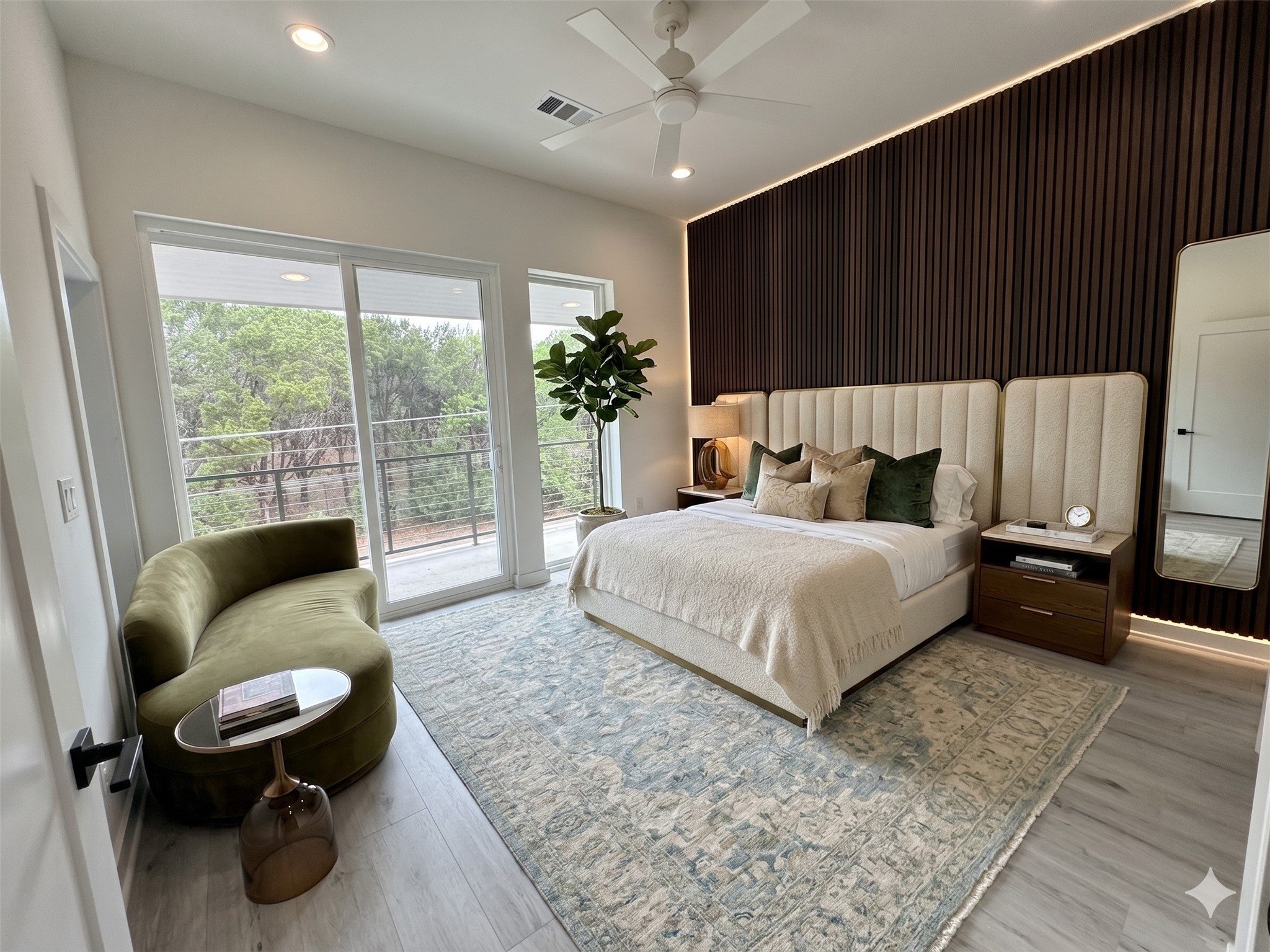 2000 Riverside Farms Road, Unit 19102 Austin, TX 78741 - Photo 5 of 13 This modern bedroom features a stylish accent wall, large windows offering plenty of natural light and views of greenery, a cozy bed, elegant side tables, and a chic green sofa. Perfect for relaxation and comfort.
