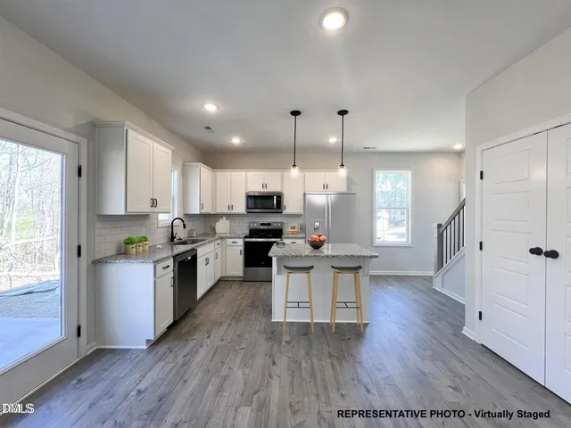 a kitchen with a sink cabinets and wooden floor