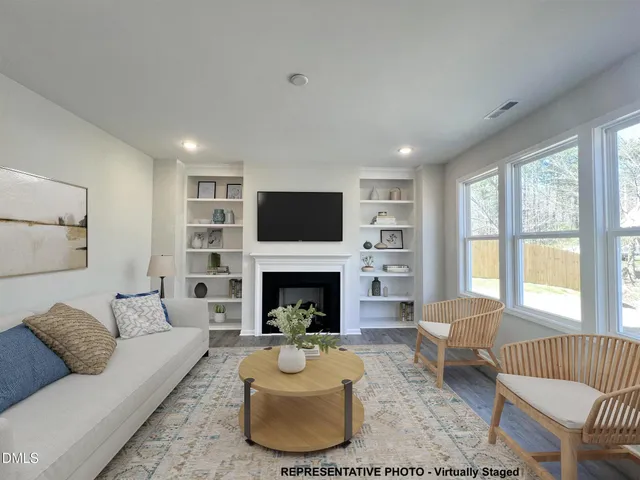 a living room with furniture a fireplace and a large window