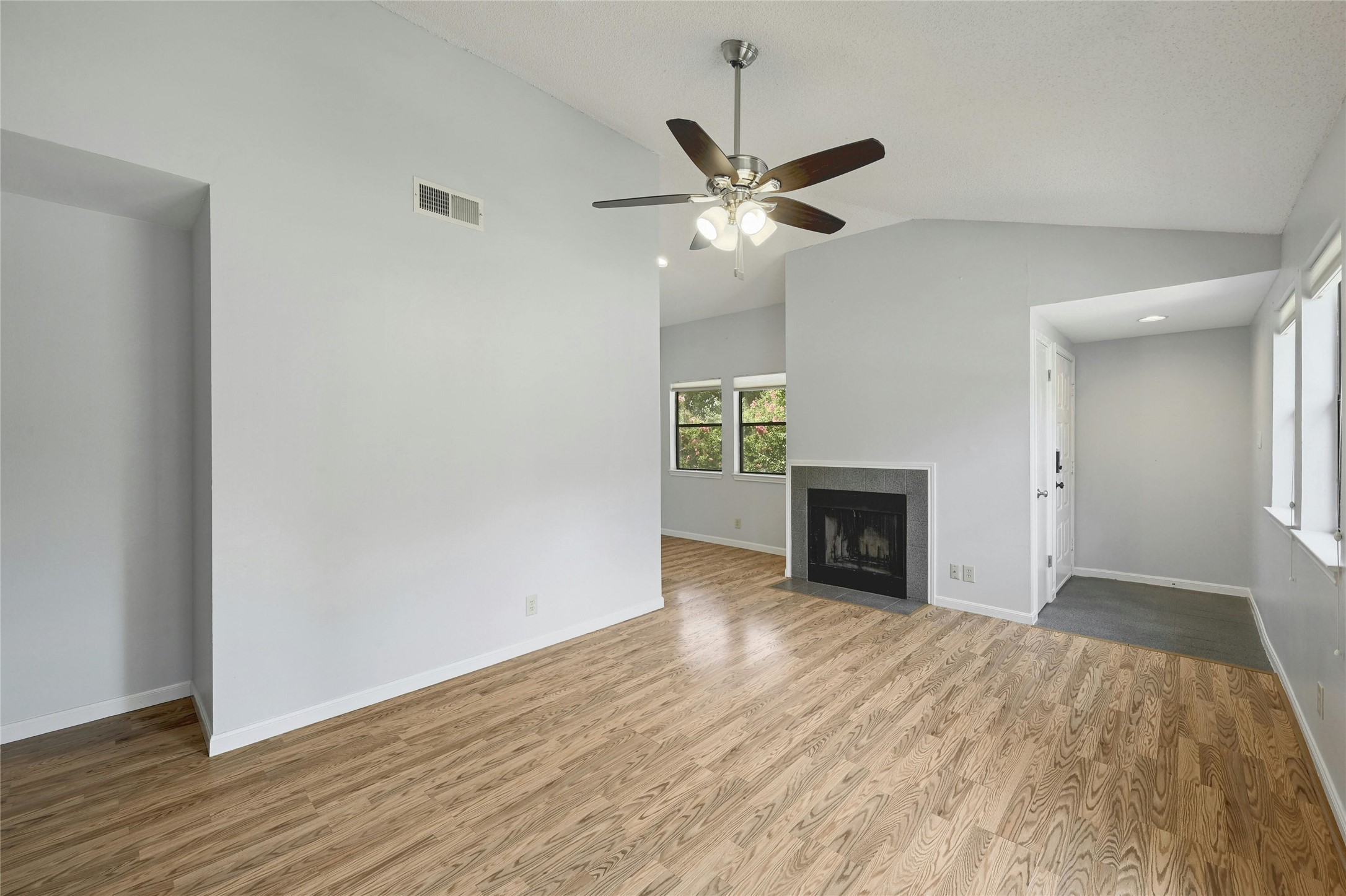 9226 Jollyville Road, Unit 221 Austin, TX 78759 - Photo 5 of 20 A living space offers a sleek fireplace with a grey surround and resilient hardwood flooring.