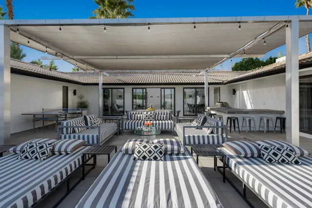 a kitchen with stainless steel appliances granite countertop a table chairs and a view of living room