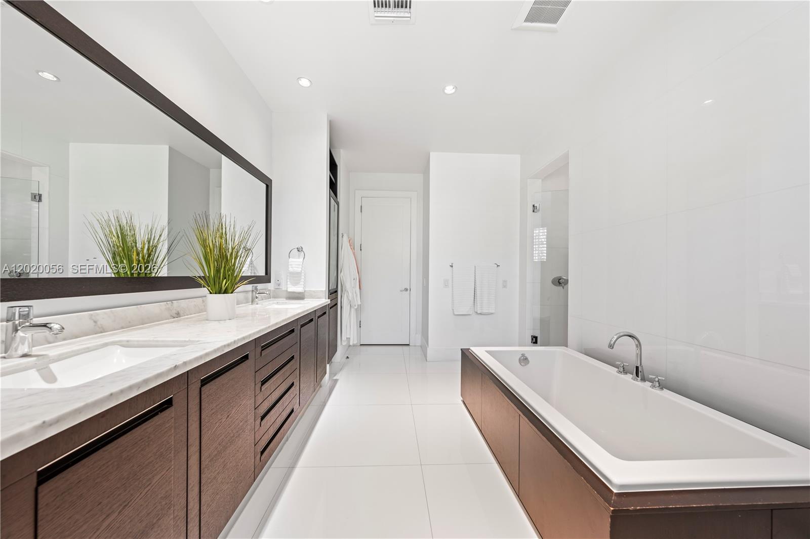 4196 Douglas Road Miami, FL 33133 - Photo 52 of 96 a spacious bathroom with a double vanity sink and mirror