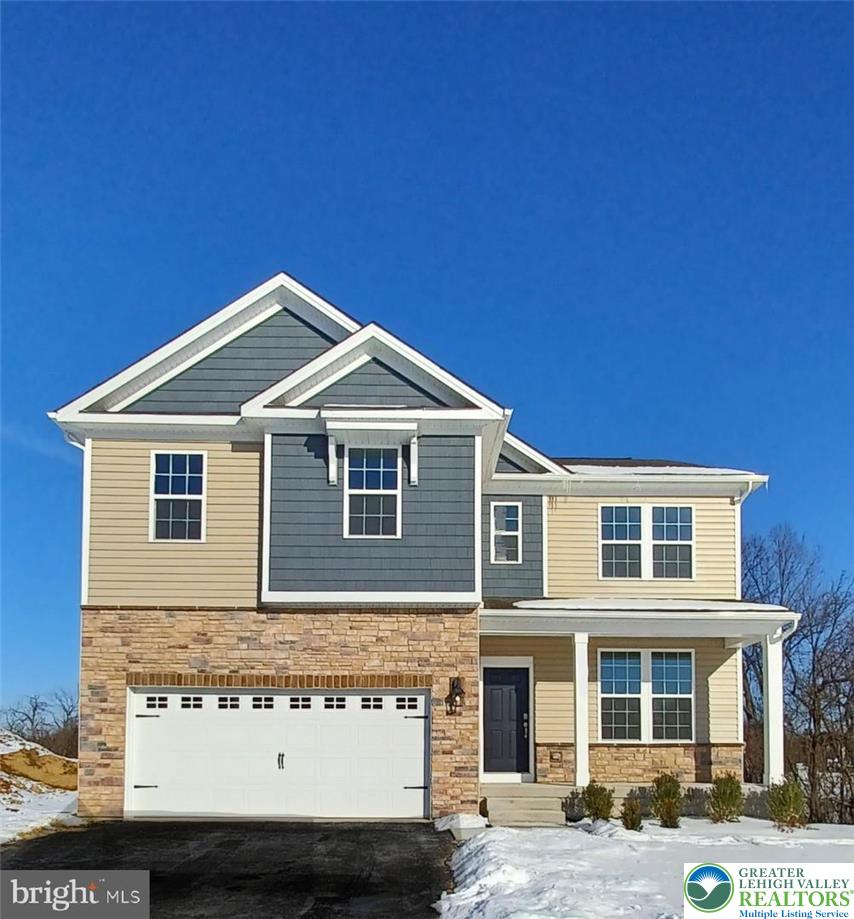 A striking contemporary residence boasts diverse textures, inviting curb appeal, and an integrated garage.