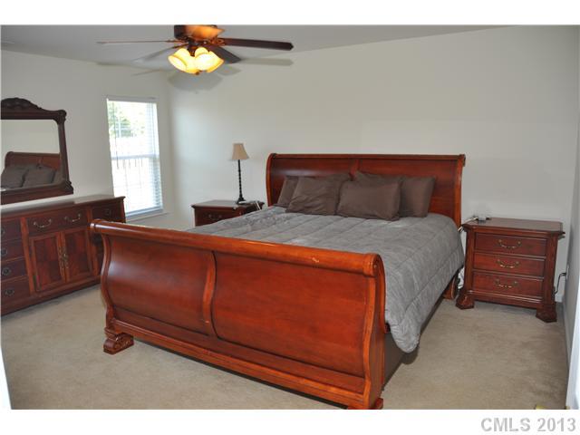 232 Royalton Road Mooresville, NC 28115 - Photo 9 of 16 a bedroom with a bed and a chandelier