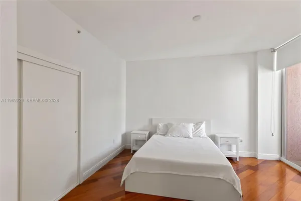 a bedroom with a bed and wooden floor