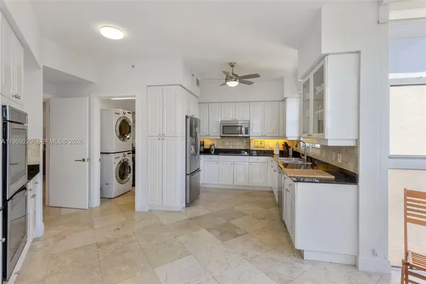 a kitchen with stainless steel appliances granite countertop a refrigerator and a stove top oven