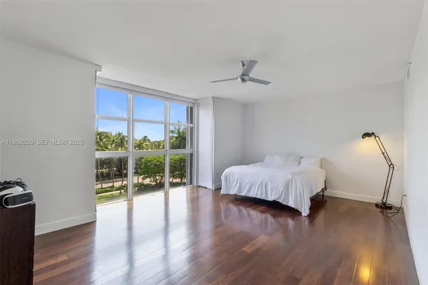a spacious bedroom with a bed and wooden floor