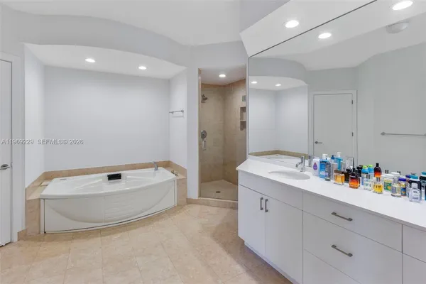 a bathroom with a tub sink a mirror and vanity