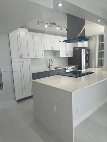 a kitchen with stainless steel appliances a sink a stove a refrigerator and cabinets