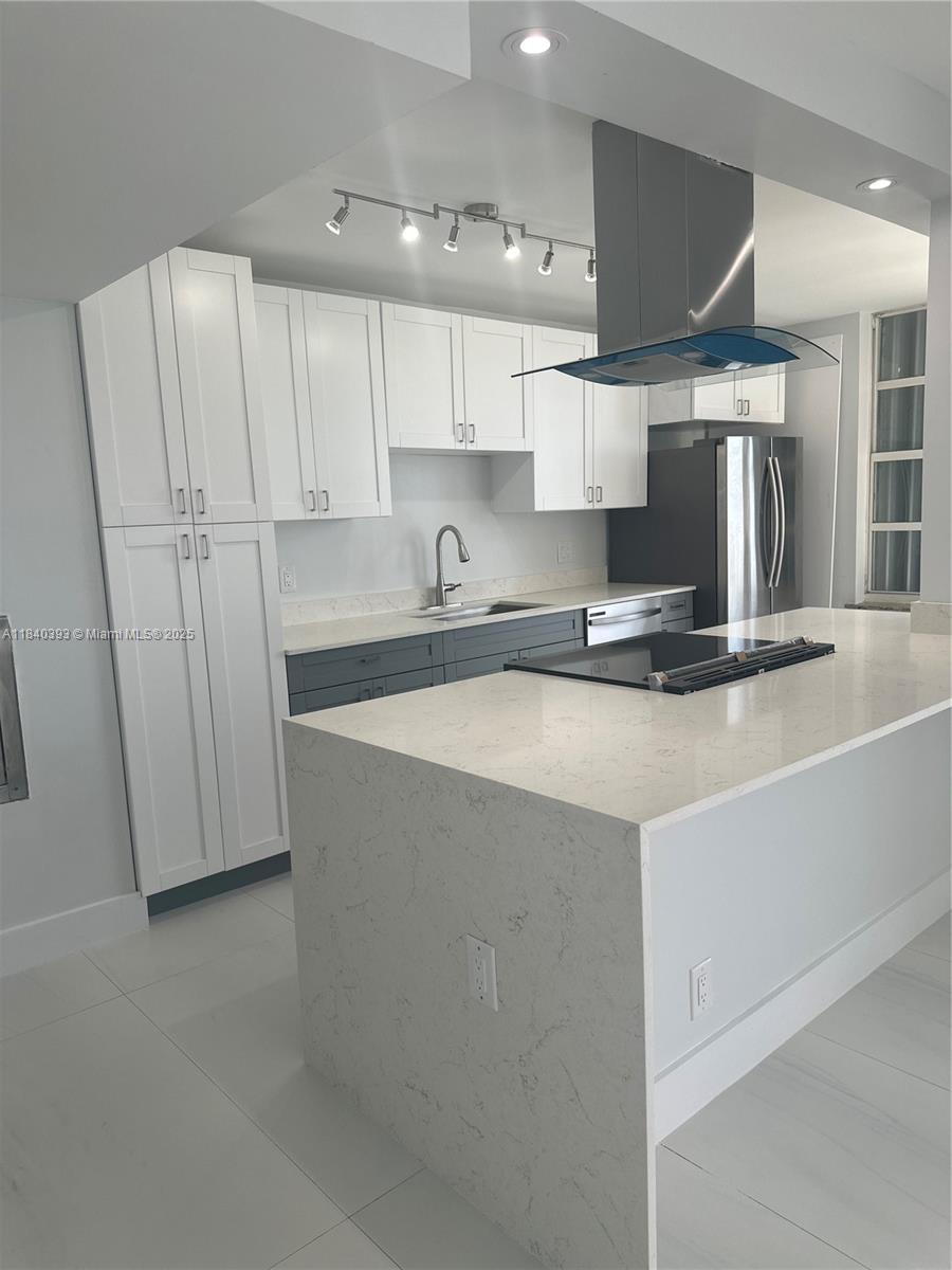 a kitchen with stainless steel appliances a sink a stove a refrigerator and cabinets