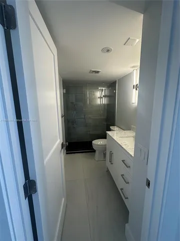 a bathroom with a double vanity sink toilet and shower
