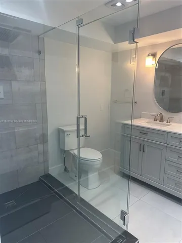 a bathroom with a granite countertop sink a toilet and shower