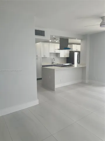 a view of kitchen with stainless steel appliances cabinets and window