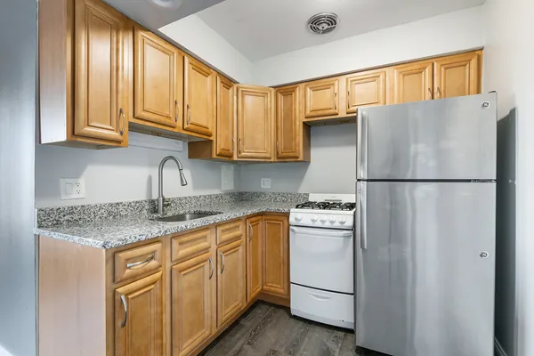 a kitchen with stainless steel appliances granite countertop a refrigerator sink and cabinets