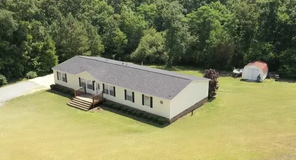 a view of a house with pool and a yard