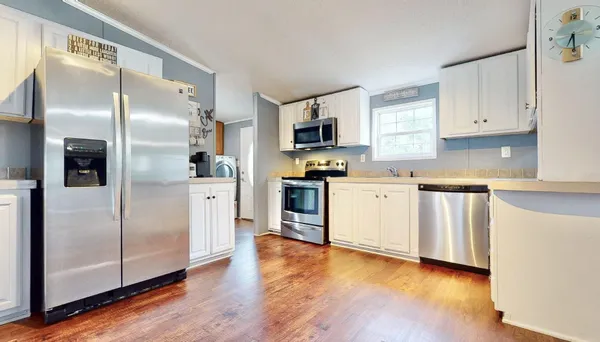 a kitchen with stainless steel appliances a refrigerator sink and microwave