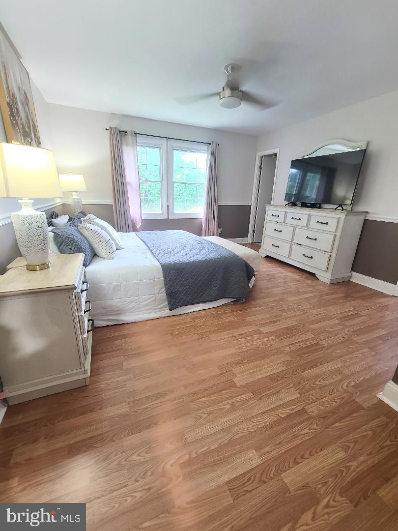 7834 Citadel Drive Severn, MD 21144 - Photo 23 of 58 a bedroom with a bed and wooden floor