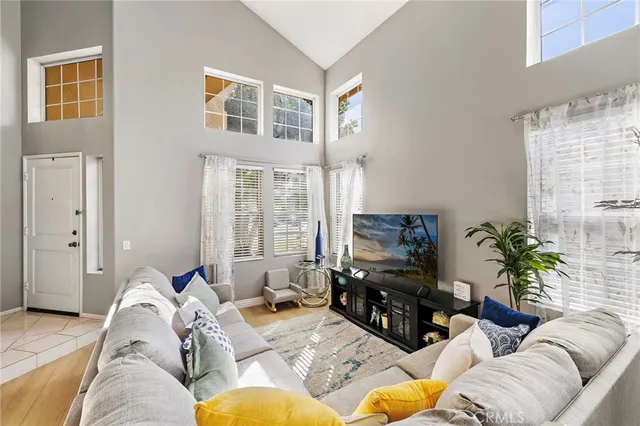 a living room with furniture a flat screen tv and potted plants
